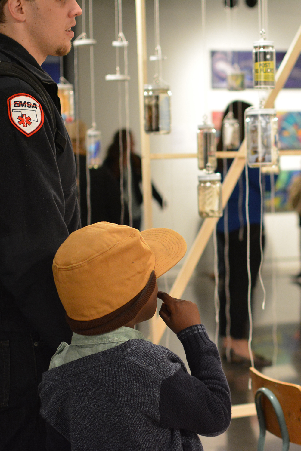 Two visitors viewing their jar after hanging it to be part of the installation.